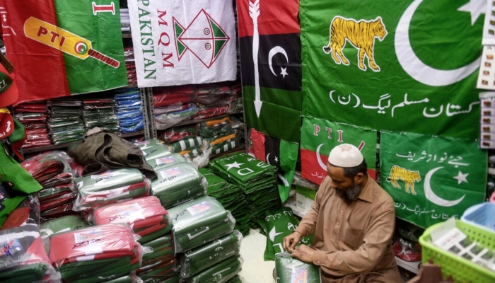 A shopkeeper in Karachi arranges flags of political parties for sale ahead of next months elections. —AFP