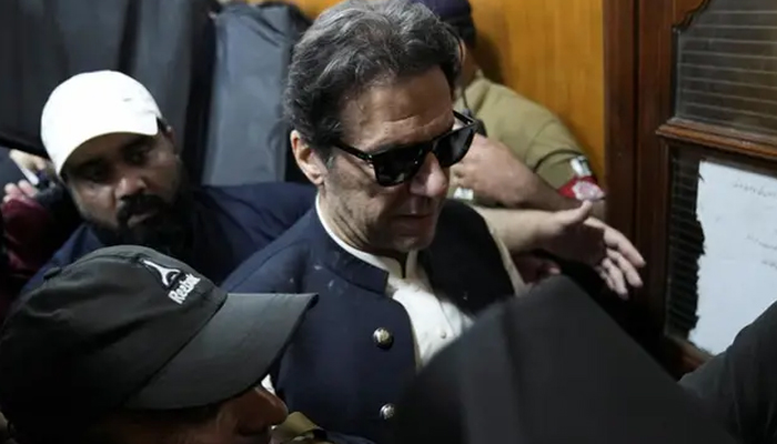 Security officers escort former prime minister Imran Khan, as he appears in Lahore High Court, on May 19, 2023. — Reuters