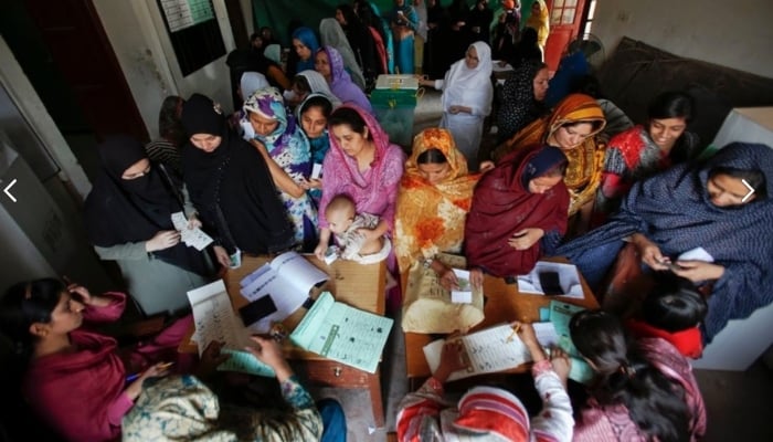 Women register and cast their ballots at a polling station in the old part of Lahore on May 11, 2013. —Reuters