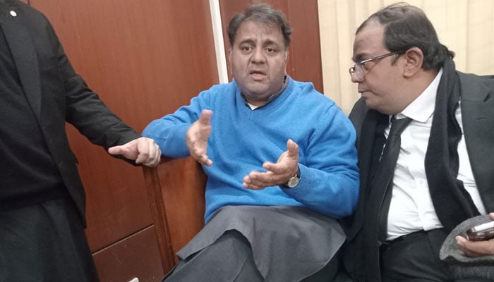 Fawad Chaudhry is seated next to his brother and lawyer Faisal Chaudhry at a court in Islamabad. — X/@TabraizAurah