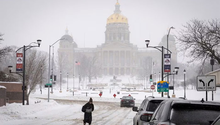 A woman walks in the street in front of Iowa state capitol after a blizzard left several inches of snow, in downtown Des Moines, Iowa, US, January 13, 2024. — Reuters