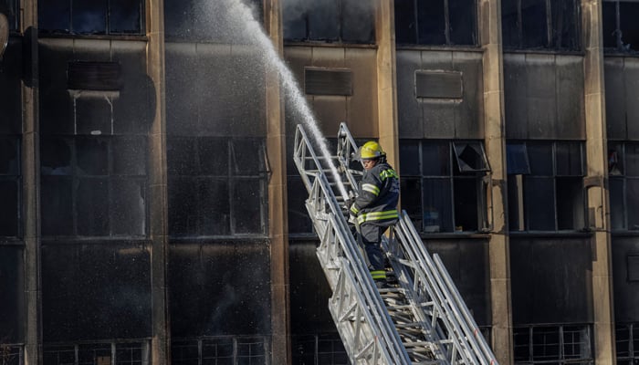 A firefighter extinguishes the fire at a building in Johannesburg on August 31, 2023. — AFP
