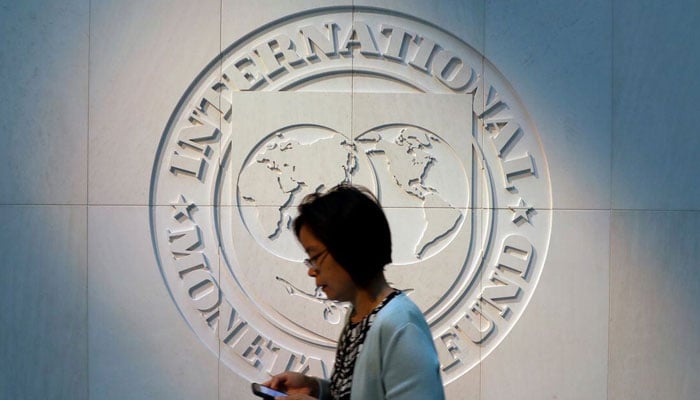 A woman walks past the International Monetary Fund (IMF) logo at its headquarters in Washington, U.S., May 10, 2018. — AFP