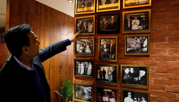 Moti Mahal Delux Managing Director Monish Gujral shows photographs of celebrities and politicians inside the restaurant in New Delhi, India, January 23, 2024. — Reuters