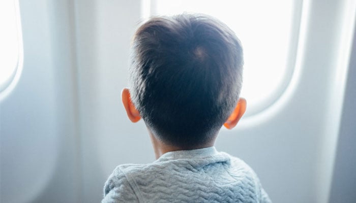 This representational picture shows a child looking out the window of a plane. — Unsplash
