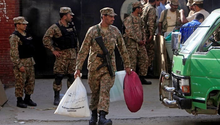 A soldier carries supplies to be delivered to a polling station from the election commission office in Lahore, on September 16, 2017. — Reuters