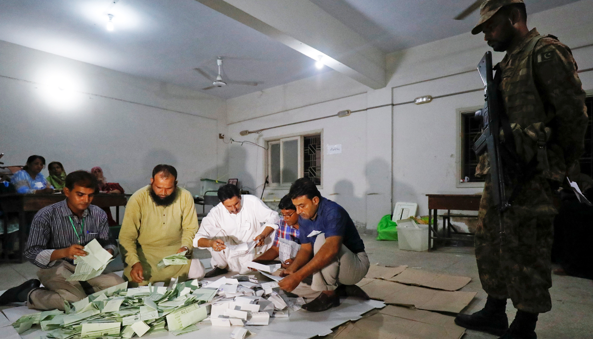 Election officials count votes after polling stations closed during the general election in Karachi, on  July 25, 2018. — Reuters