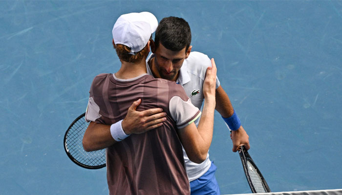 Italy´s Jannik Sinner is congratulated by Serbia´s Novak Djokovic following his victory in their men´s singles semi-final match on day 13 of the Australian Open tennis tournament in Melbourne on January 26, 2024. — AFP
