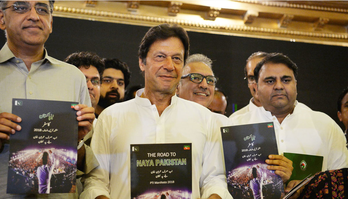 PTI leaders display copies of their partys manifesto. —AFP