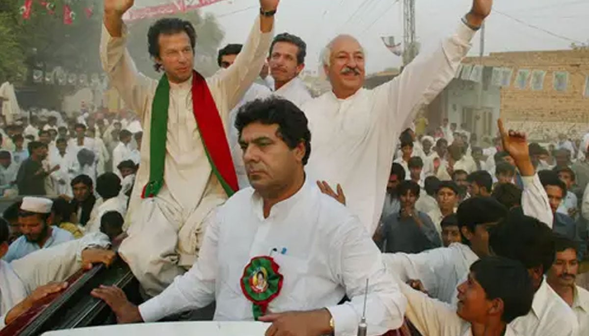 Imran Khan, in the green-and-red scarf, waving to supporters at a campaign rally in Shadi Khal, in October 2002. — Business Recorder