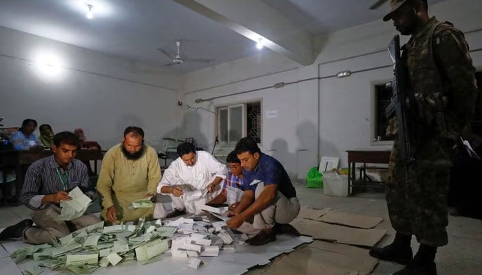 Election officials count votes after polling stations closed during the general election in Karachi, Pakistan, July 25, 2018. — Reuters