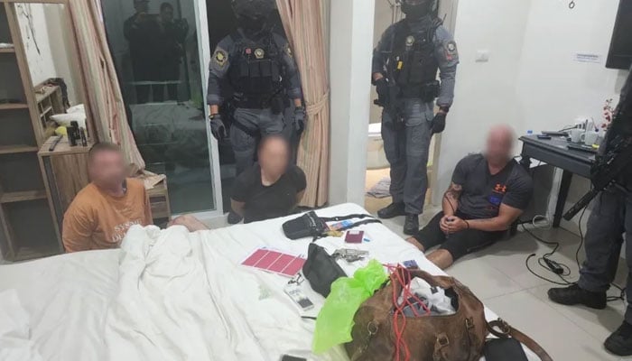 This image shows Ian Days mates sitting on the floor with hands tied by Thai authorities. — Viral Press