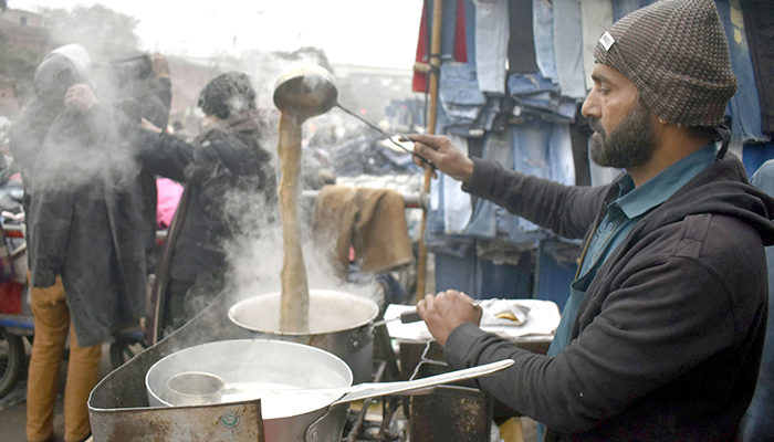 A vendor is preparing tea for customers at Empress Road in Lahore, on January 9, 2024. — Online
