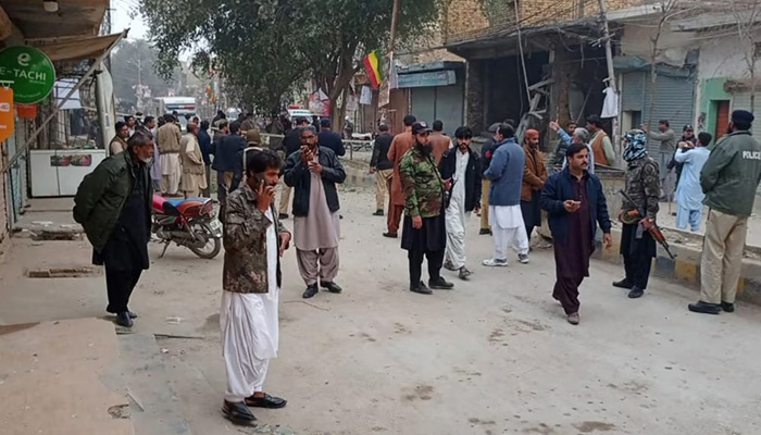 Security personnel and people gather near the site of a bomb explosion in Sibi, Balochistan, January 30, 2024. — AFP