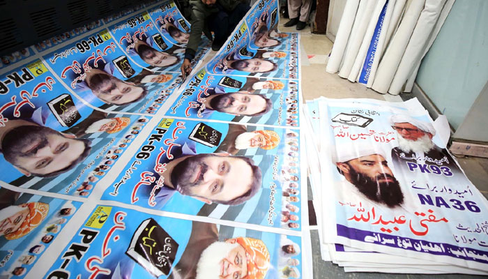 Worker busy in preparing general election candidate banner on his workplace for publicity on ahead of start General Election in Peshawar. — INP