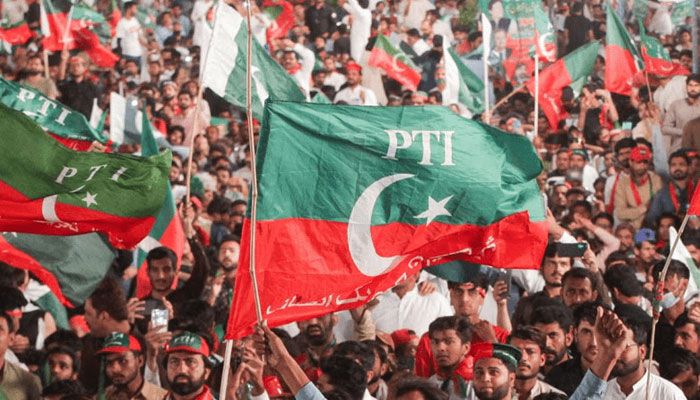 A crowd of PTI supporters wave the partys flag. — PTI