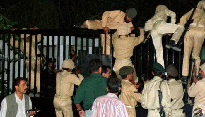 Army men climb over the main gate of PTV HQ in Islamabad during the military coup of 1999. —Reuters