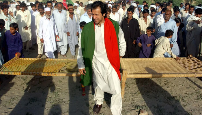 عمران خان 3 اکتوبر 2002 کو کنڈل کے ایک دور افتادہ علاقے میں گھر گھر انتخابی مہم کے دوران ایک چھوٹی ریلی کی قیادت کر رہے ہیں۔ —اے ایف پی