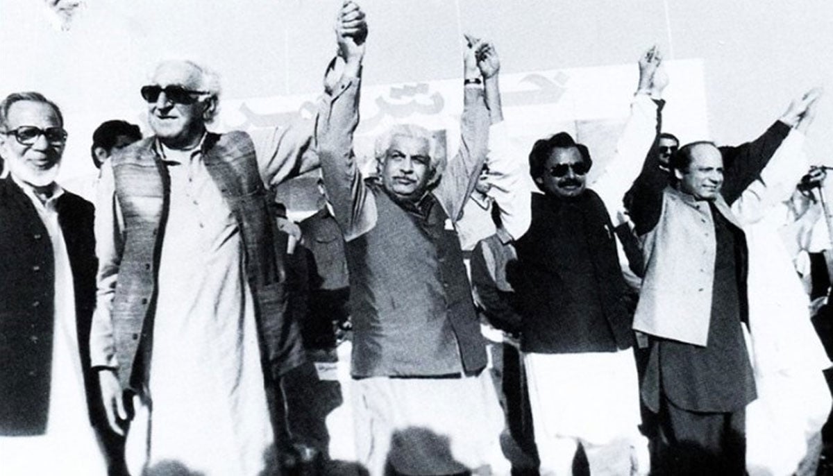 Professor Ghafoor Ahmed (left) stands next to Khan Abdul Wali (second from left) as he raises hands with Ghulam Mustafa Jatoi, Altaf Hussain and Nawaz Sharif at an event in 1990. — Flickr/Dr Ghulam Nabi Kazi
