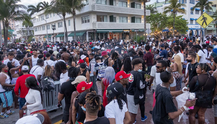 A large crowd of people participate in a party on a walkway near the beach, during spring break in Miami Beach, Fla., U.S., March 20, 2021. — EPA