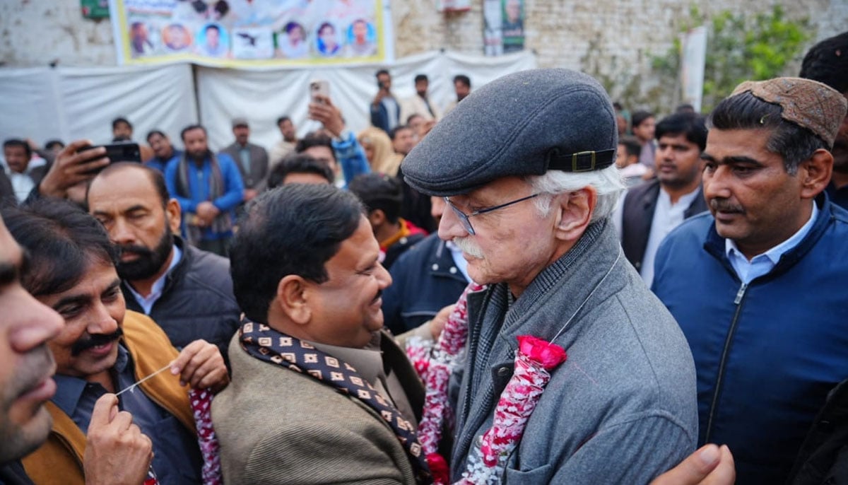 Jahangir Tareen hugs a party leader at a public meeting in this undated picture. —Facebook