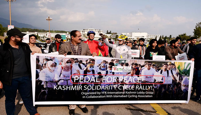 People displaying banner during PEDAL for Peace Kashmir solidarity cycle rally from D-Chowk to Islamabad Press Club organized by YFK-International Kashmir Lobby Group in collaboration with Islamabad Cycling Association. — APP
