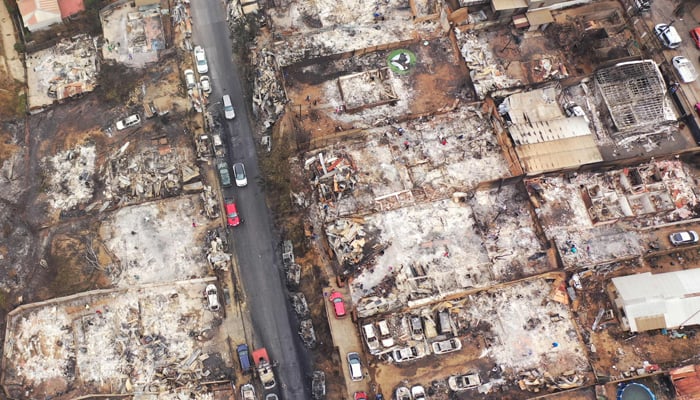 Aerial view of burned homes and vehicles after a forest fire in Quilpue, Viña del Mar, Chile, taken on February 4, 2024. — AFP