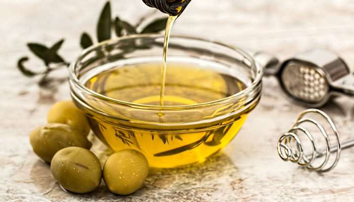 A bowl of olive oil and olives. — Unsplash