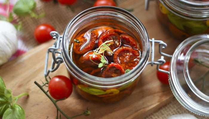 A jar of cherry tomatoes filled with olive oil. — Pixabay