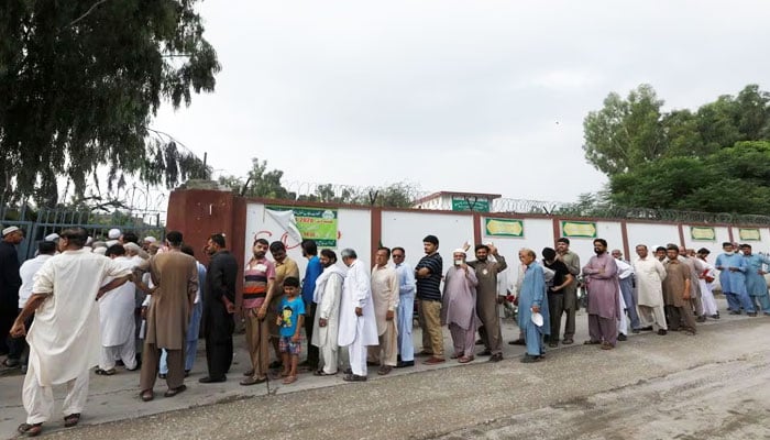 People stand in a line as they wait for a polling station to open, during the general election in Rawalpindi, Pakistan July 25, 2018. — Reuters