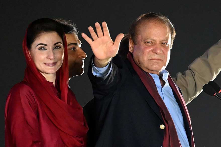 Former prime minister Nawaz Sharif (R) stands beside his daughter Maryam Nawaz (L) as he waves to his supporters gathered at a park during an event held to welcome him in Lahore on October 21, 2023. —AFP