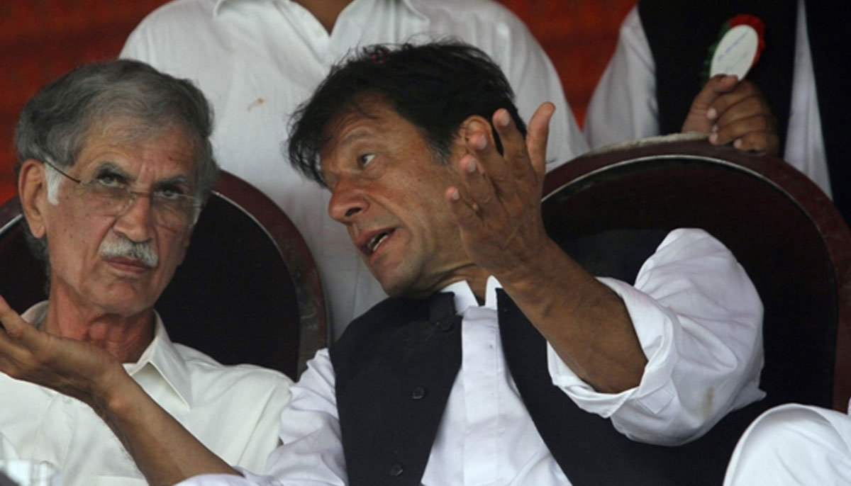PTI chief Imran Khan talks with party leader Pervaiz Khattak. —Reuters