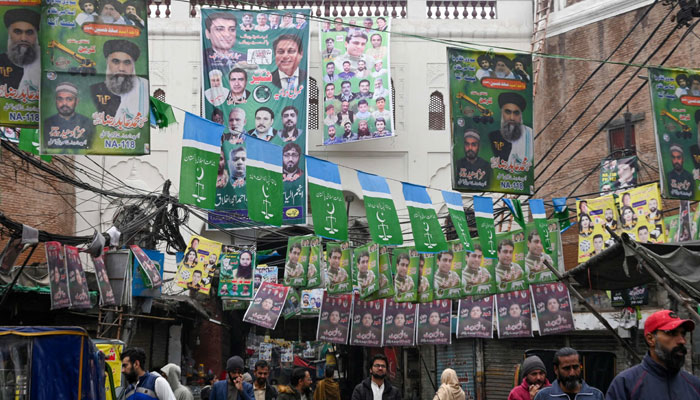 A street is festooned with banners of political parties ahead of Pakistan´s national elections 2024, in Lahore on February 4, 2024. — AFP