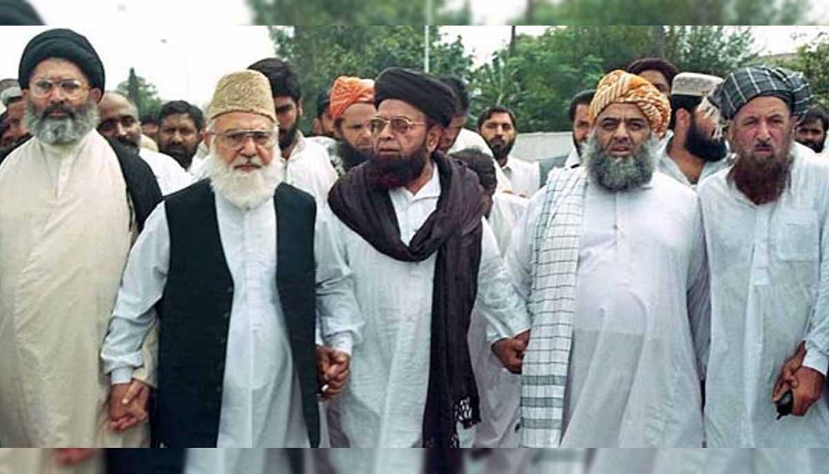 (Left to right) JI Ameer Qazi Hussain Ahmad, Maulana Shah Ahmad Noorani, and Maulana Fazlur Rehman, stand hand in hand during an MMA rally in the 2002 election in this undated picture.—Online