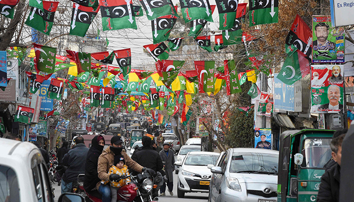 This photo taken on February 3, 2024, shows a street festooned with flags of political parties ahead of national elections in Quetta. — AFP