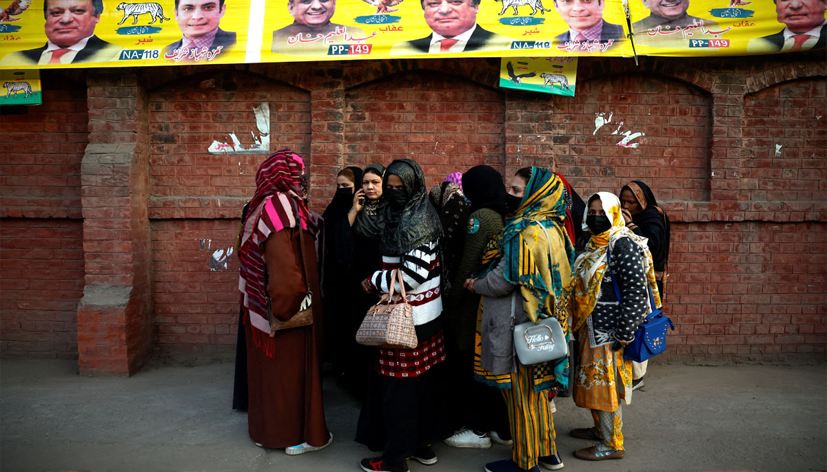 Women wait outside a polling station for voting to begin on the day of the general election, in Lahore, Pakistan February 8, 2024. — Reuters