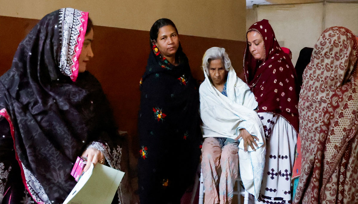 Women volunteers help Sughra Bibi, 93, as she arrives to cast a vote during the general election in Karachi, Pakistan February 8, 2024. — Reuters