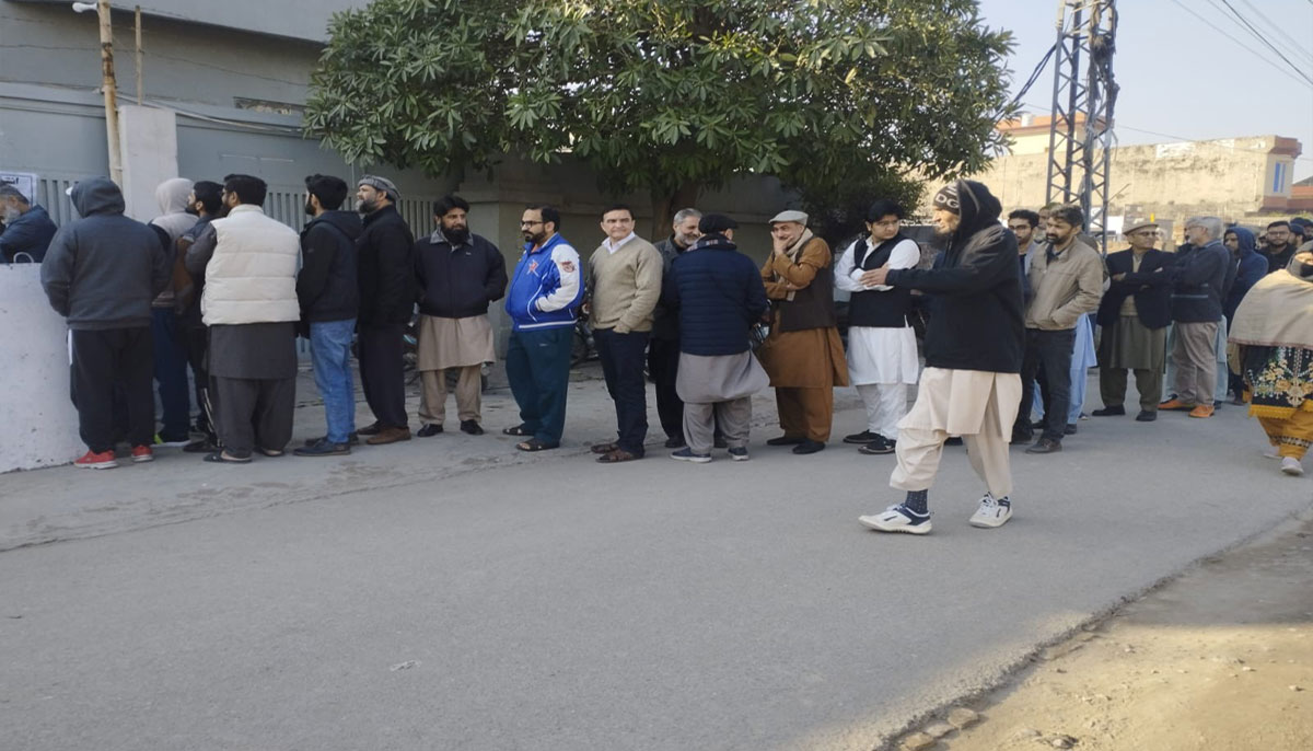 The picture shows people standing outside polling station. — X/@PTI