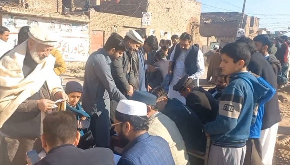 The picture shows people standing outside polling station. — X/@PTI