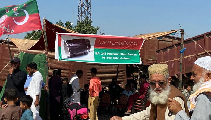 Voters stand outside a PTI camp office in Karachi on February 8, 2024. — Geo.tv