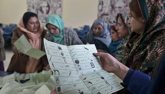 Polling officials counting votes at a polling station in G-7 area, Islamabad during general election on February 8, 2024. — APP