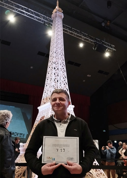 Richard Plaud, a Frenchman who built a model of the Eiffel Tower using 706,900 matchsticks poses next to the structure measures 7.19m in Saujon, France, January 7, 2024. — Reuters