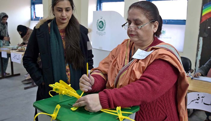Polling official opens a ballot box to count votes at a polling station in F-6 area, Islamabad during general elections on February 8, 2024. — APP