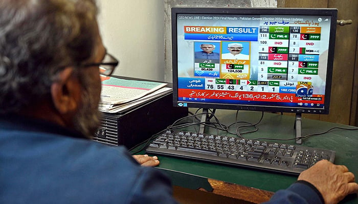 A man watching latest election results live streaming on Geo News on a computer screen in this undated photo. — APP