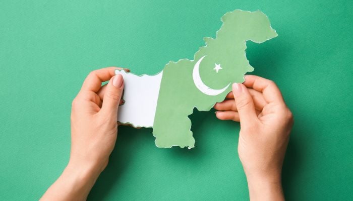 The picture shows a person holding Pakistans map. — Canva