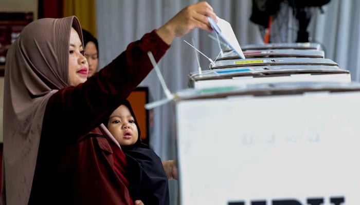 A woman votes at a polling station during the general election in Bogor, West Java, Indonesia, February 14, 2024. — Reuters