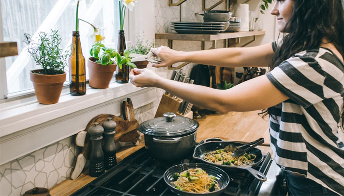 A woman cooking in er kitchen. — Unsplash