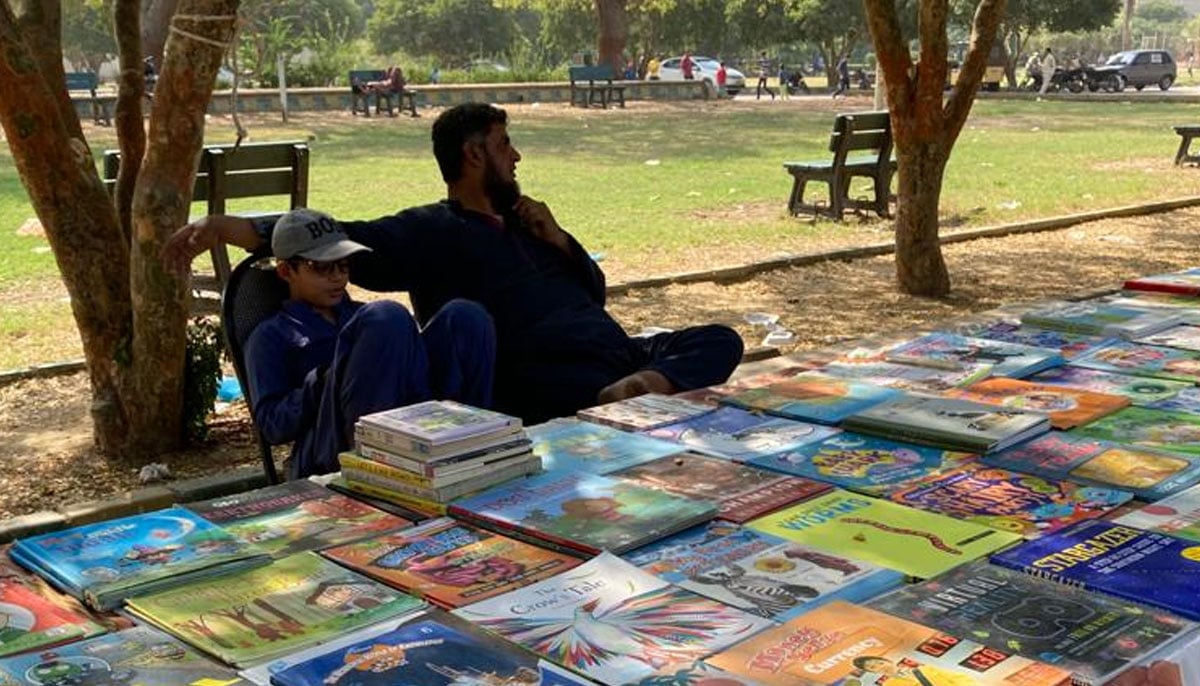 A bookseller is seated with his son before his weekly Sunday book stall at the Frere Hall. — Photo by author