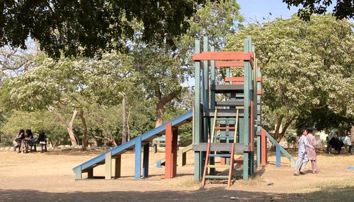 Women are seen seated on a bench near swings at the Frere Hall. — Photo by author