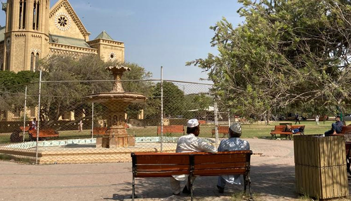 Men sit together on a bench at the Frere Hall. — Photo by author